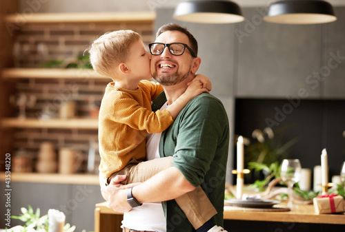 Little son kissing happy dad, congratulating him with Fathers day