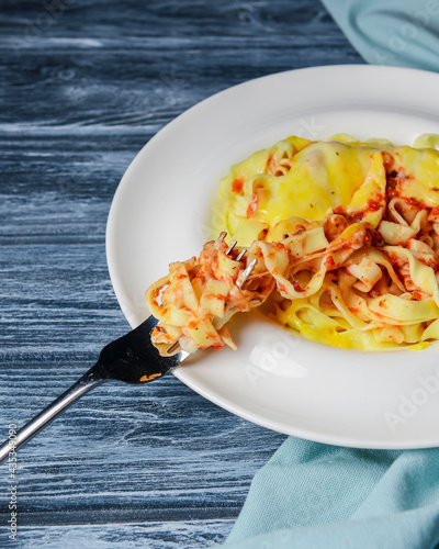 Spaghetti pasta with cheese and pepper, served in a white plate over rustic gray wooden table. photo