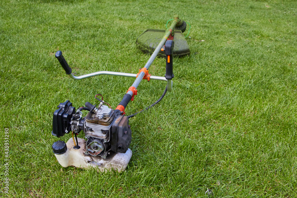 trimmer broken on the grass,Petrol trimmer disassembled on the grass trimmer broken on the grass,Petrol trimmer disassembled on the grass