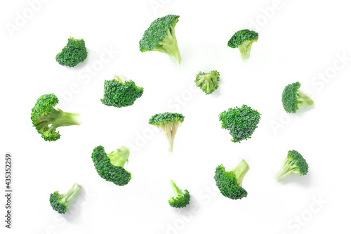Broccoli florets falling on a white background. Cut pieces of green broccoli