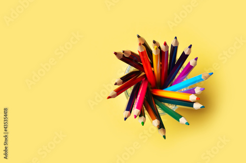 Colorful pencils above on yellow background, back to school theme