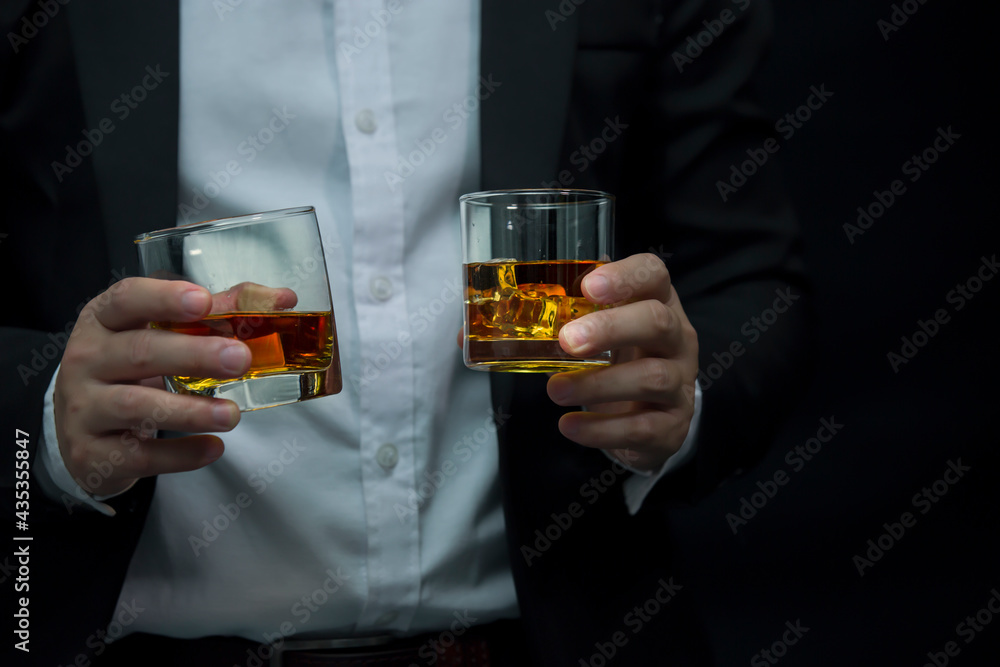 Closeup businessmen holding a glass of whiskey Closeup businessmen holding a glass of whiskey