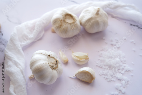 Whole garlic, garlic cloves and fabric on a white background