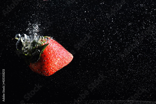 Water drops on ripe sweet strawberry. Fresh berry background with copy space for your text. Vegan food concept.