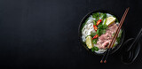 Pho Bo vietnamese soup with beef and rice noodles on a black background, top view, copy space