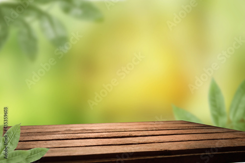 empty space on a wooden table for your product on an abstract green sunny background.