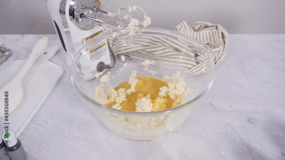 Step by step. Mixing ingredient in a mixing bowl with an electric mixer to bake vanilla Mardi Gras cupcakes.