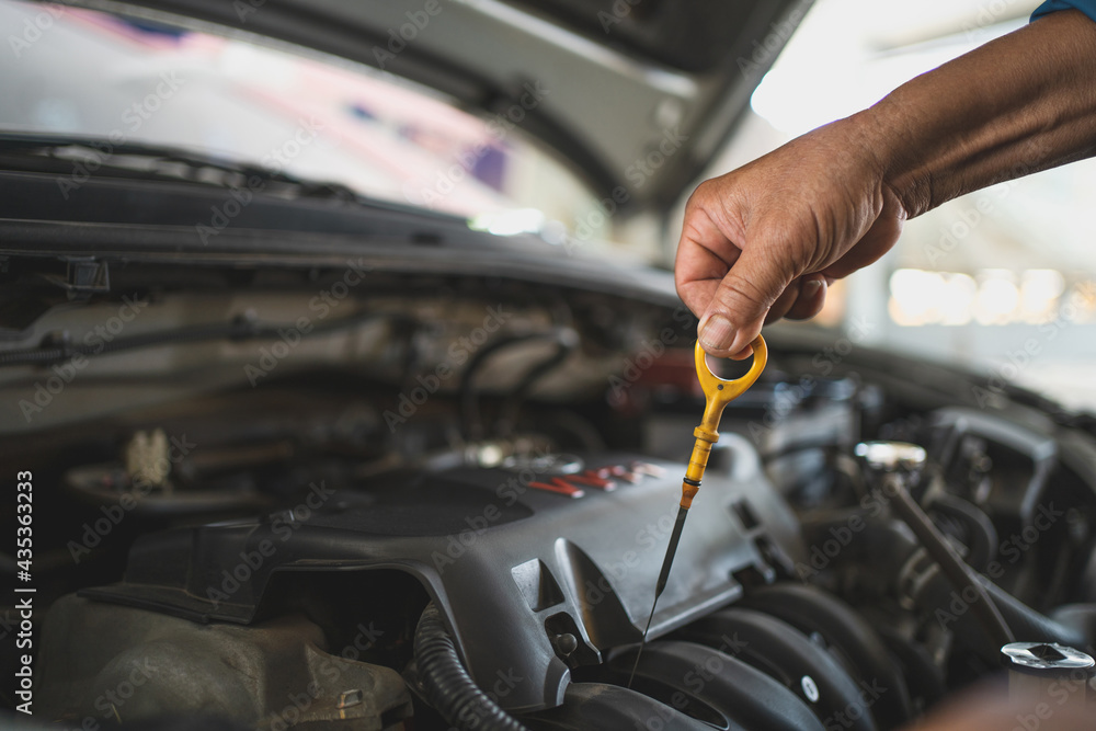 Obraz premium Mechanic checks the car oil in the vehicle. Car service center