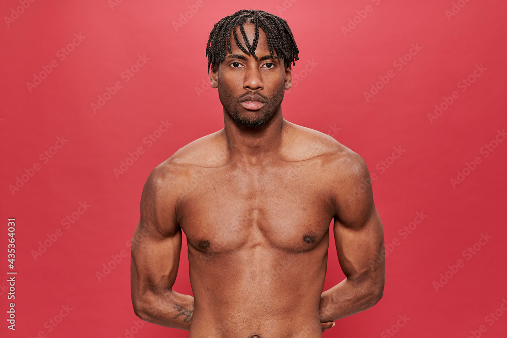 Fototapeta premium Black man without shirt on red background