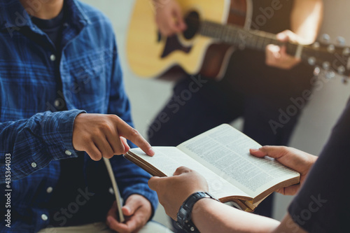 Fotografi Christian family worship God in home with  playing guitar, and holding holy bible