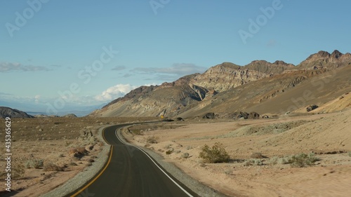 Road trip to Death Valley  Artists Palette drive  California USA. Hitchhiking auto traveling in America. Highway  colorful bare mountains and arid climate wilderness. View from car. Journey to Nevada.