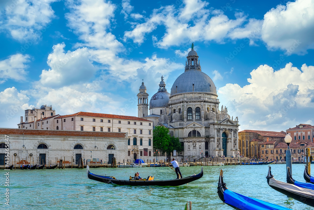 Grand canal with gondola and Basilica di Santa Maria della Salute in Venice, Italy. Architecture and landmarks of Venice. Venice postcard
