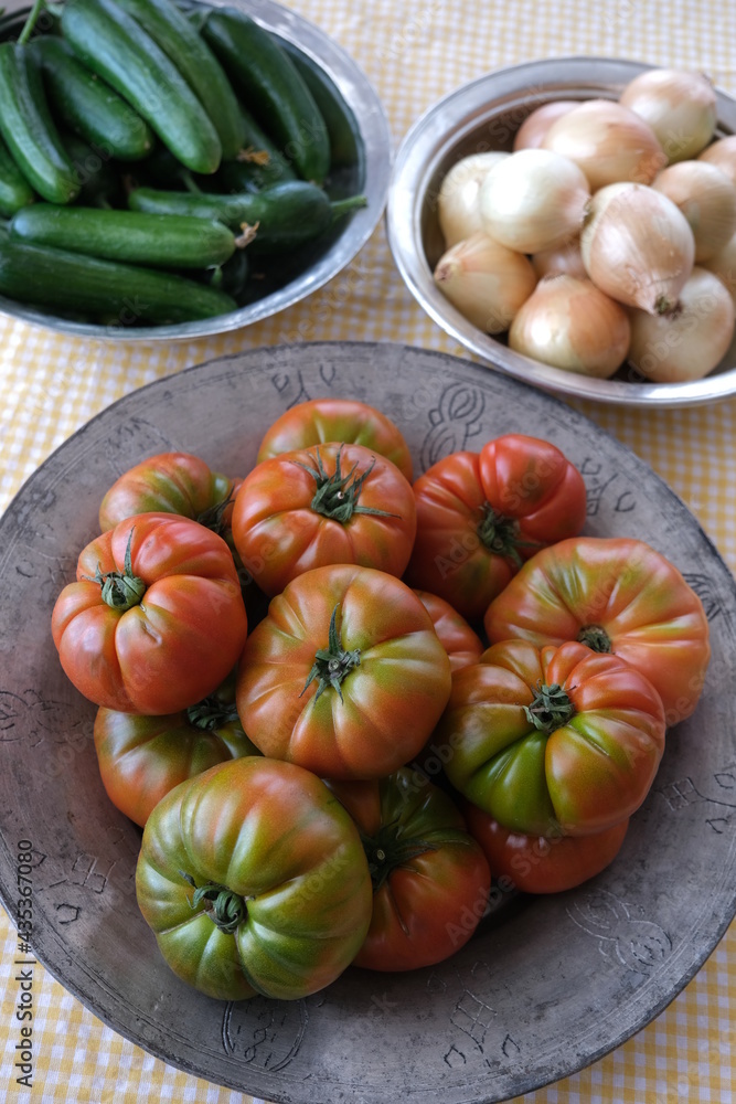 Freshly harvested tomatoes, cucumbers and onions in old copper pots Freshly harvested tomatoes, cucumbers and onions in old copper pots