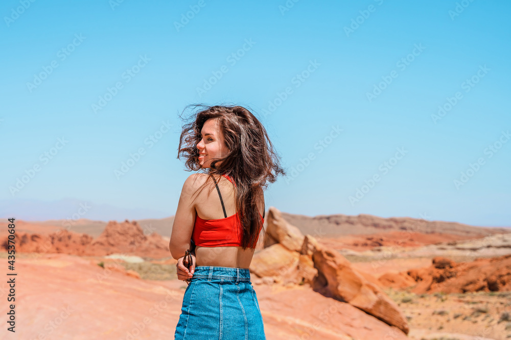 Portrait of a happy brunette woman in the Valley of Fire in Nevada overlooking a desert landscape Portrait of a happy brunette woman in the Valley of Fire in Nevada overlooking a desert landscape
