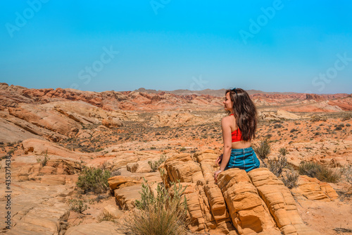 Portrait of a happy brunette woman in the Valley of Fire in Nevada overlooking a desert landscape