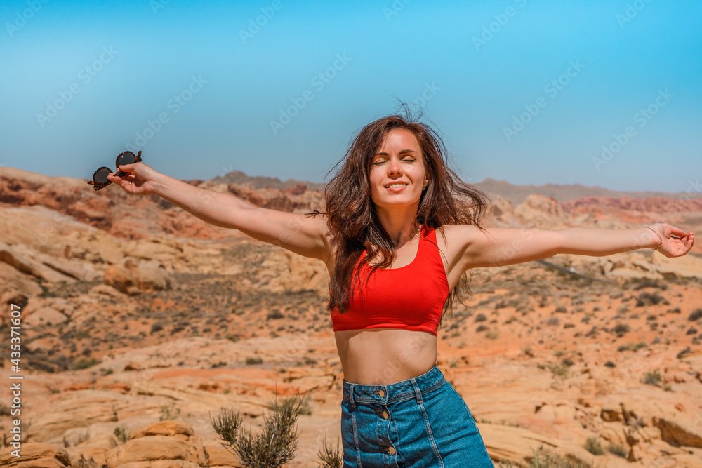 Portrait of a happy brunette woman in the Valley of Fire in Nevada overlooking a desert landscape Portrait of a happy brunette woman in the Valley of Fire in Nevada overlooking a desert landscape