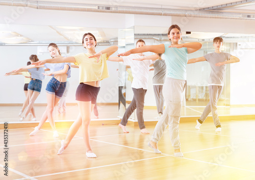 Positive teenagers are dancing hip hop in dance studio