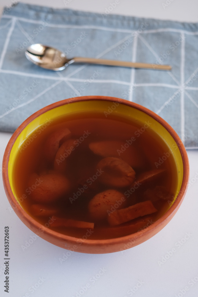 Compote in ceramic bowl on wooden stand.Delicious healthy compote made from dried fruits.
Apricot in spoon Compote in ceramic bowl on wooden stand.Delicious healthy compote made from dried fruits.
Apricot in spoon