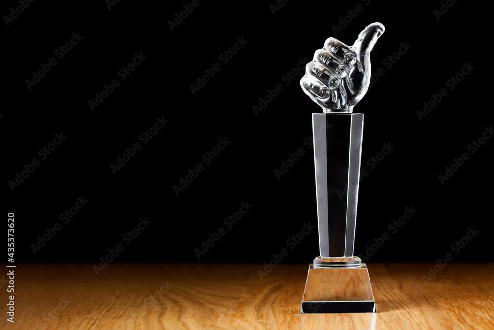 Glass thumb trophy on the wooden table