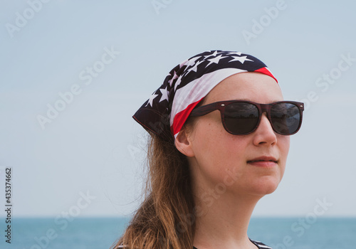 Confident girl in sunglasses american flag bandana. USA Independence Day patriotism concept, Memorial Day, national pride. Study English, US visa, Green card. Real authentic people lifestyle portrait.