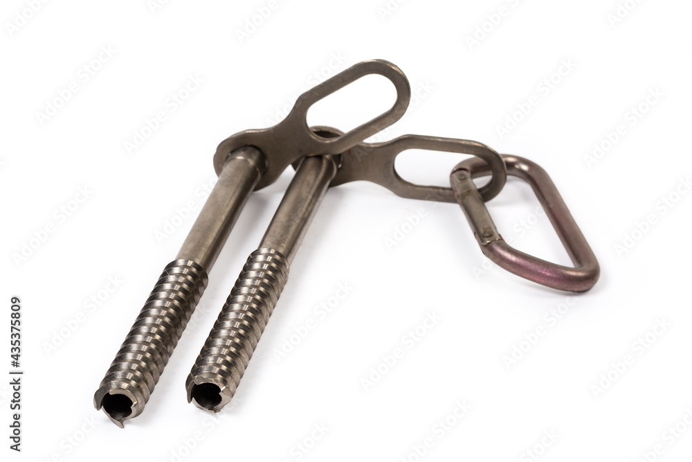 Two ice screws with carabiner inserted in one of them Two ice screws with carabiner inserted in one of them
