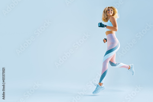 Sportswoman feeling happy. Caucasian female in sportswear running. Motivation fitness concept photo with copy space