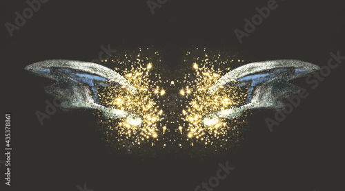 Golden glitter on abstract blue watercolor wings on black background