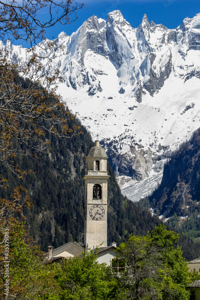 The reformed church tower and the mountain range Sciora in the mountain village Soglio, canton of the Grisons, Switzerland. It is credited as one of the most beautiful Swiss villages.
