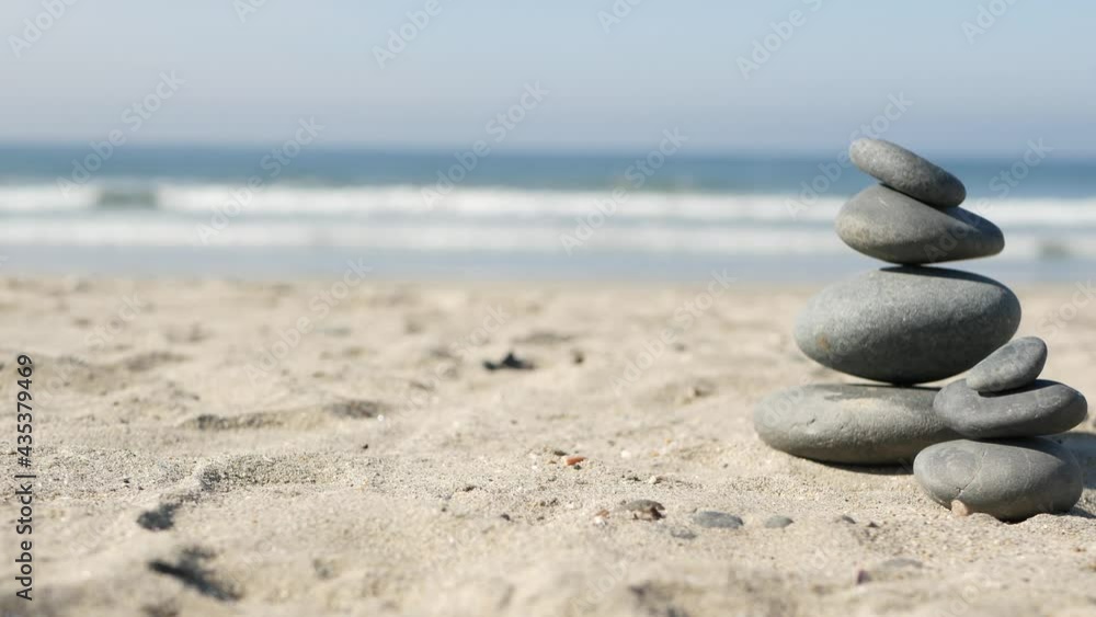 Rock balancing on ocean beach, stones stacking by sea water waves. Pyramid of pebbles on sandy shore. Stable pile or heap in soft focus with bokeh, close up. Zen balance, minimalism, harmony and peace Rock balancing on ocean beach, stones stacking by sea water waves. Pyramid of pebbles on sandy shore. Stable pile or heap in soft focus with bokeh, close up. Zen balance, minimalism, harmony and peace
