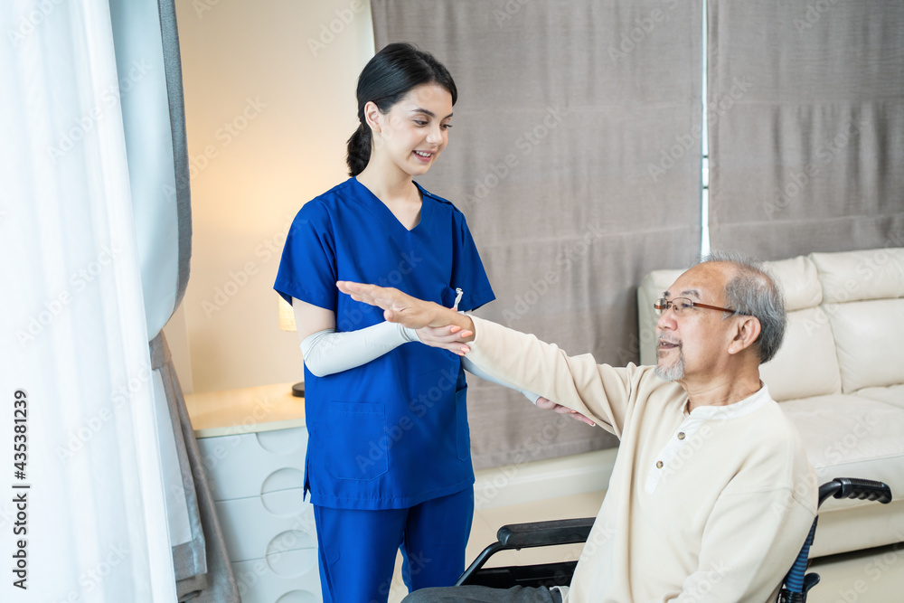 Obraz premium Asian female nurse providing physiotherapy service to senior patient.