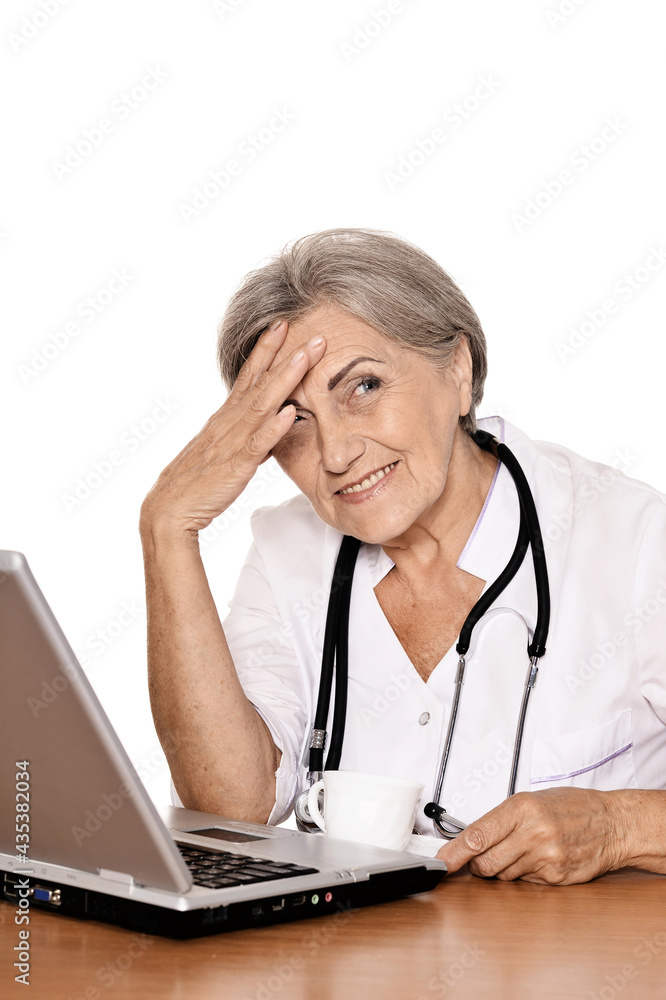 Confident female doctor sitting at table with laptop Confident female doctor sitting at table with laptop