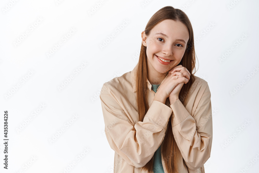 So adorable. Beautiful young girl admire something cute, looking with admiration and tenderness, smiling silly, standing happy against white background So adorable. Beautiful young girl admire something cute, looking with admiration and tenderness, smiling silly, standing happy against white background