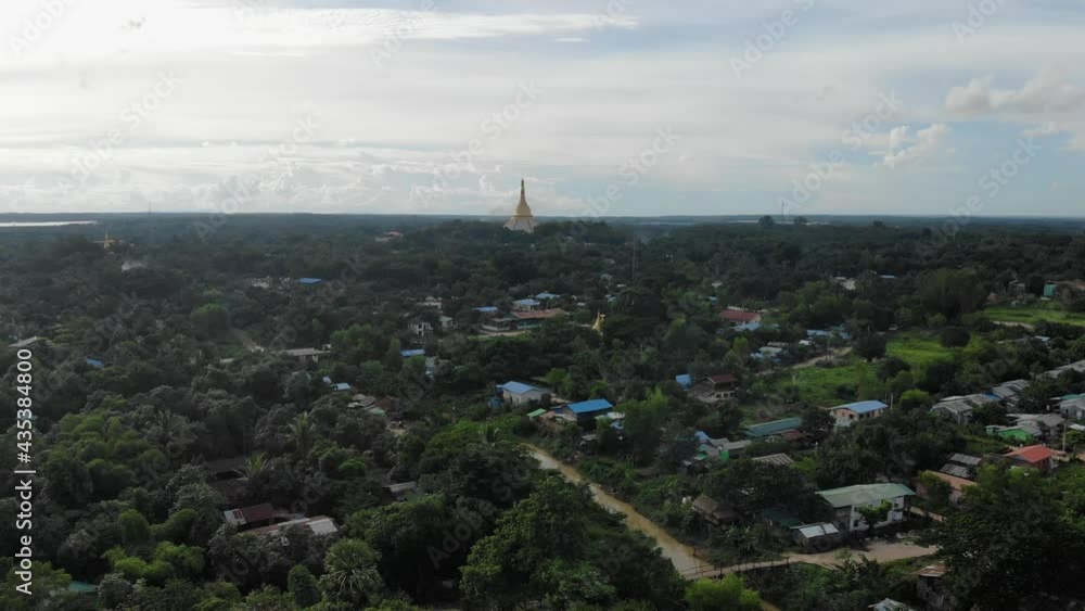 Drone flying over the historical city of Bago in Myanmar with Shwemawdaw Pagoda in the distant sunset Drone flying over the historical city of Bago in Myanmar with Shwemawdaw Pagoda in the distant sunset