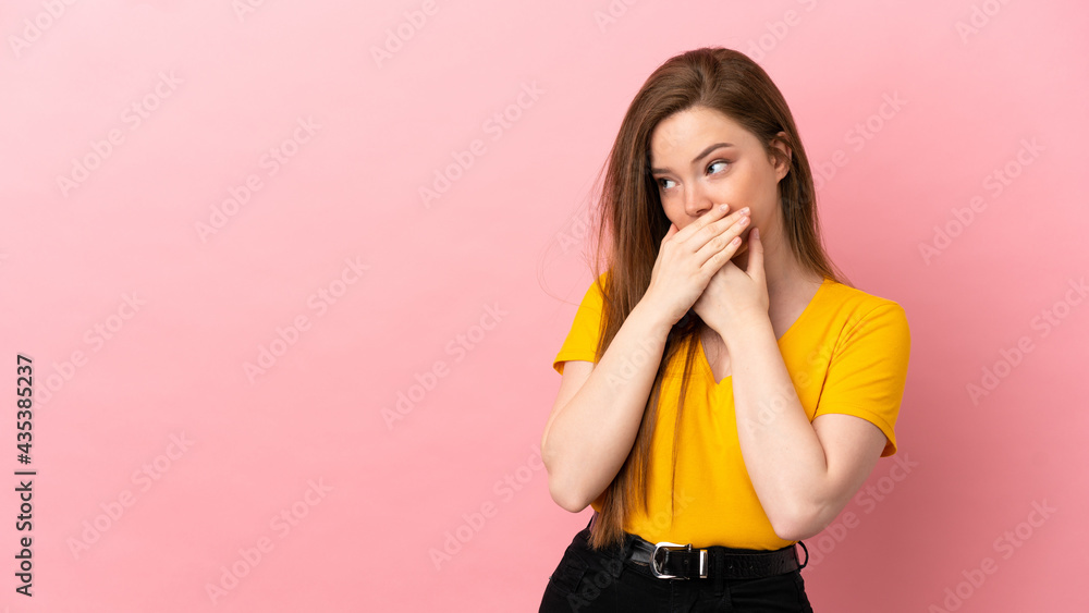 Teenager girl over isolated pink background covering mouth and looking to the side Teenager girl over isolated pink background covering mouth and looking to the side