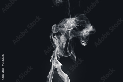 Fototapeta Naklejka Na Ścianę i Meble -  White smoke creating abstract shapes on a black background