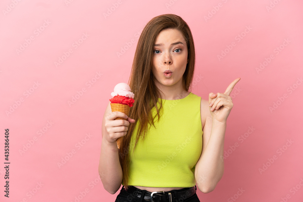 Teenager girl with a cornet ice cream over isolated pink background intending to realizes the solution while lifting a finger up Teenager girl with a cornet ice cream over isolated pink background intending to realizes the solution while lifting a finger up