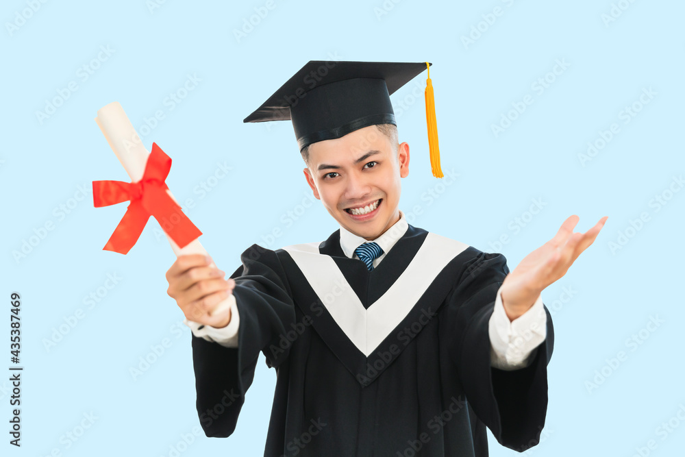 Excited young man in black graduation gown and cap holding a diploma Excited young man in black graduation gown and cap holding a diploma