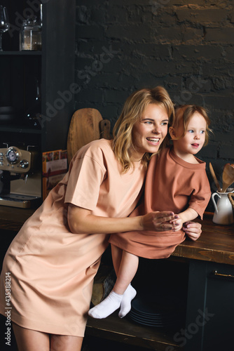Portrait of a young mom and preschool daughter in the kitchen. Spending time with your family.