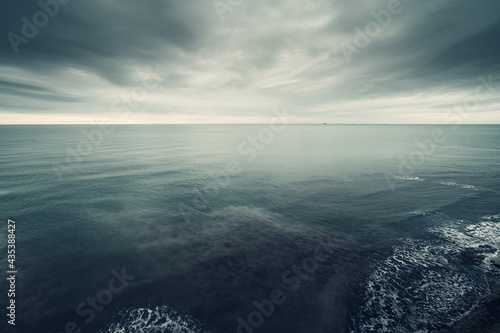 Dramatic seascape, dark blue clouds and sea or ocean water surface, time before storm.