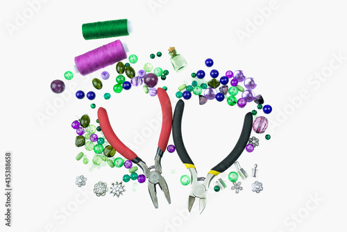 Jewellery findings of different kinds, green and violet beads isolated on a white background. photo