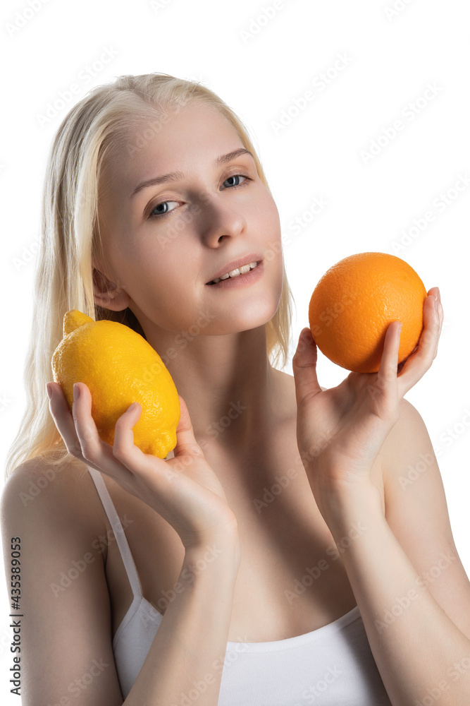 Young blond woman with lemon and orange isolated on a white background. Young blond woman with lemon and orange isolated on a white background.