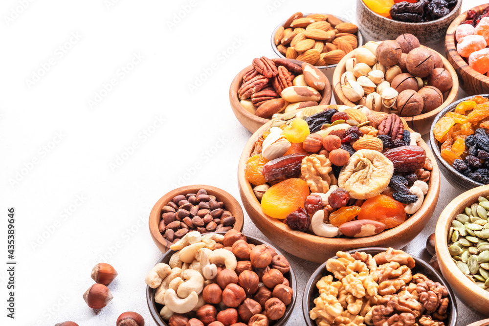 Obraz premium Nuts and dried fruits. Dried apricots, figs, raisins, pecans, walnuts, hazelnuts, almonds and other. White background, top view
