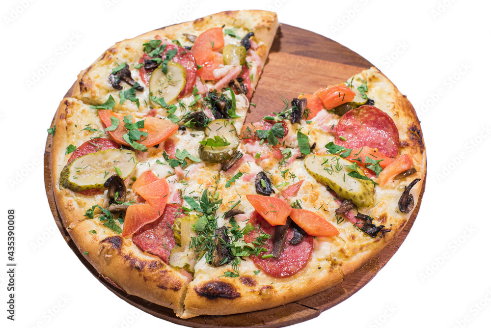 Pizza with salami, mushrooms, pickled cucumbers and tomatoes on a wooden plate isolated on white background