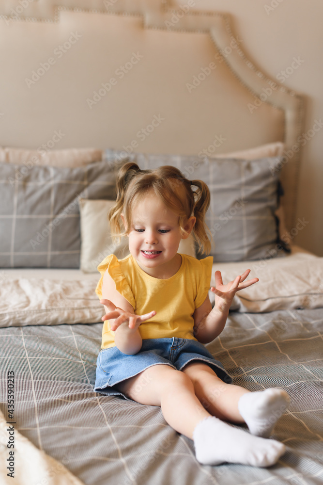 Portrait of little preschool girl fooling around on bed at home Portrait of little preschool girl fooling around on bed at home