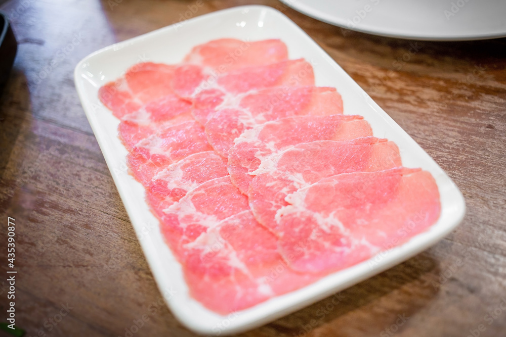 Fresh beef raw sliced was served for Sukiyaki and Shabu or Yakiniku restaurant which it put on white plate. Fresh beef raw sliced was served for Sukiyaki and Shabu or Yakiniku restaurant which it put on white plate.