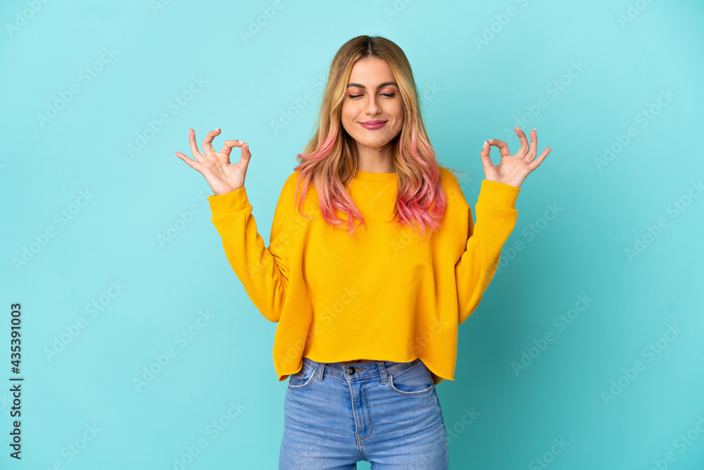 Young woman over isolated blue background in zen pose Young woman over isolated blue background in zen pose