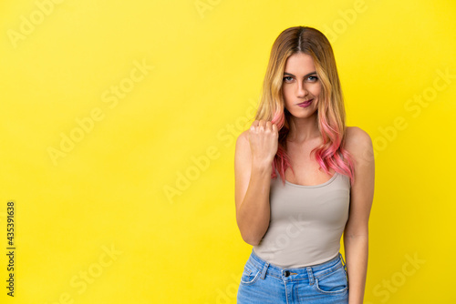Young woman over isolated yellow background with unhappy expression
