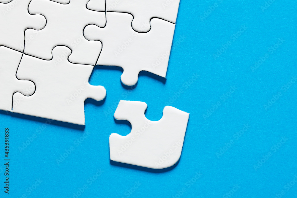 Obraz premium One missing puzzle piece on blue background with copy space. Connection or separation concept.