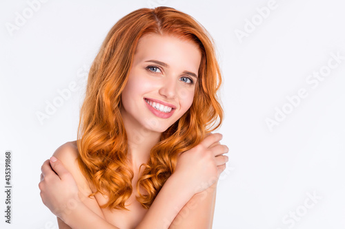 Photo portrait of girl with curly red hair with natural soft skin embracing herself smiling isolated white color background