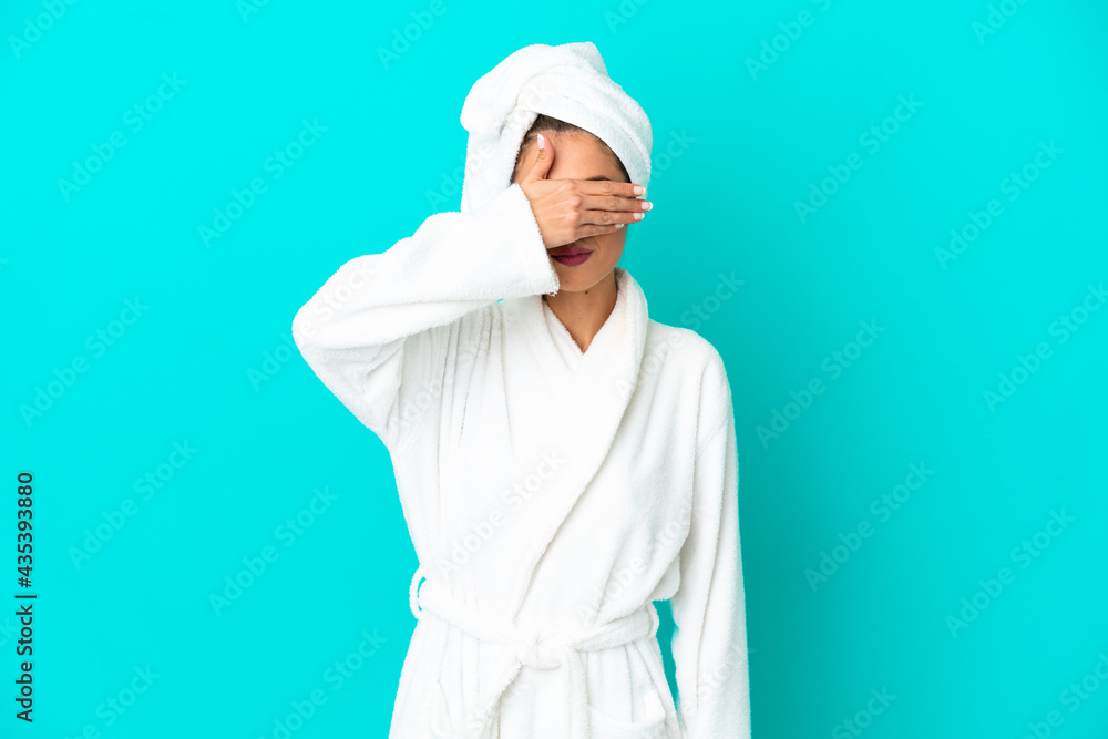 Young woman in a bathrobe over isolated blue background covering eyes by hands. Do not want to see something Young woman in a bathrobe over isolated blue background covering eyes by hands. Do not want to see something